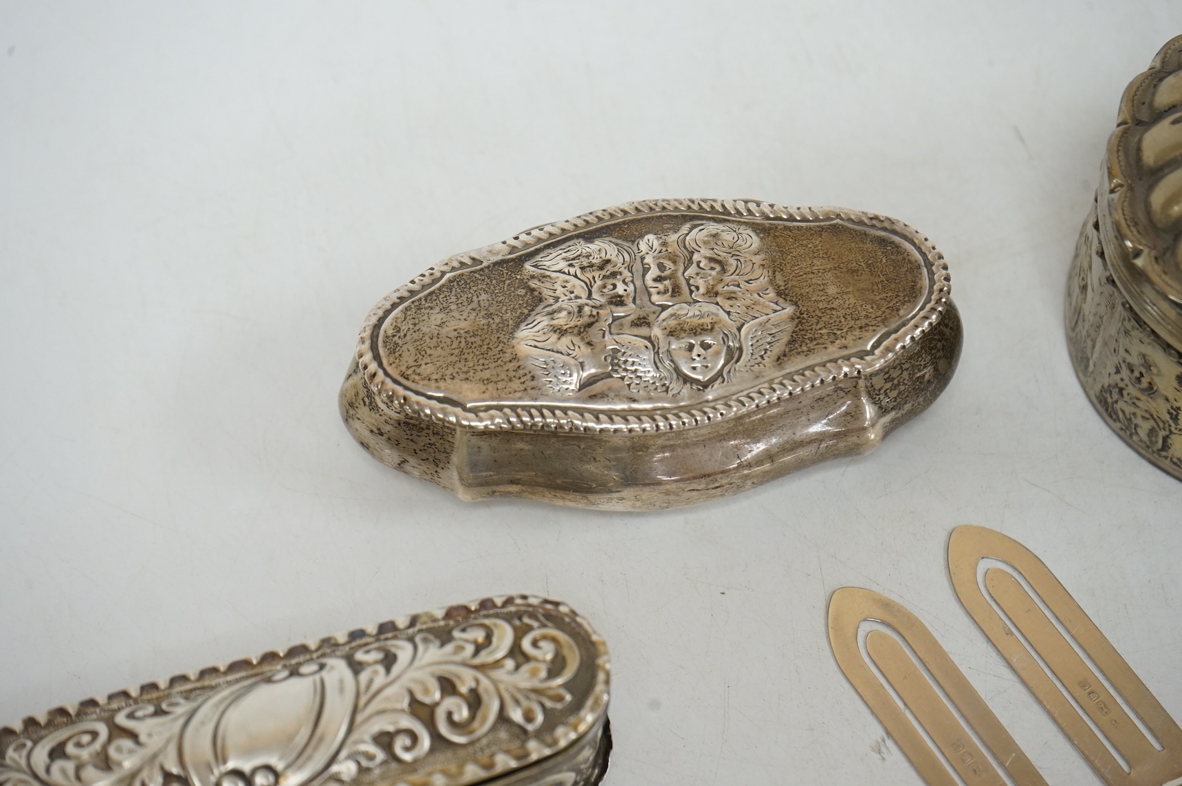 Three late 19th/early 20th century repousse silver trinket boxes, including one with Reynold's Angels decoration, Birmingham, 1899, 91mm, a larger 19th century Dutch white metal oval box and cover, a pair of wishbone sil